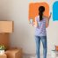 A woman compares paint colours on an accent wall