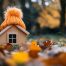 A charming miniature house warmly covered by a knitted cap, nestled among colorful autumn leaves, ready for winter.